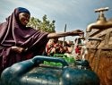 Habiba Hossen is collecting water from a rehabilitated distribution point in Kole Community.