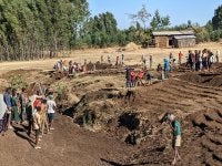 A group of people working the land.