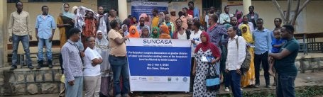Group holding banner.