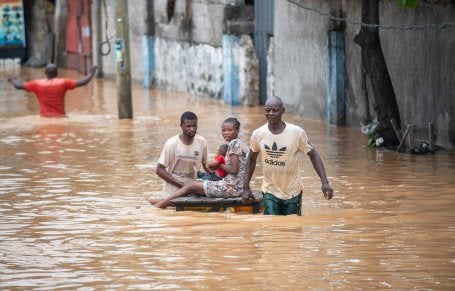 People navigating a flooded street amid a flooding disaster