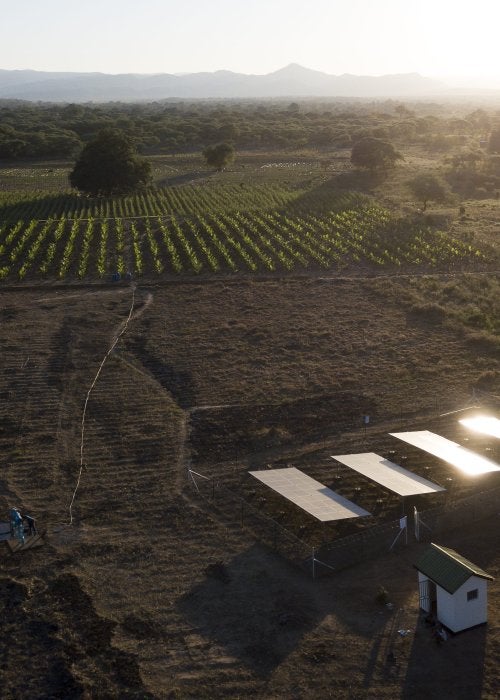 Overhead view of a small farm operation powered by a solar panel array in the bottom corner.