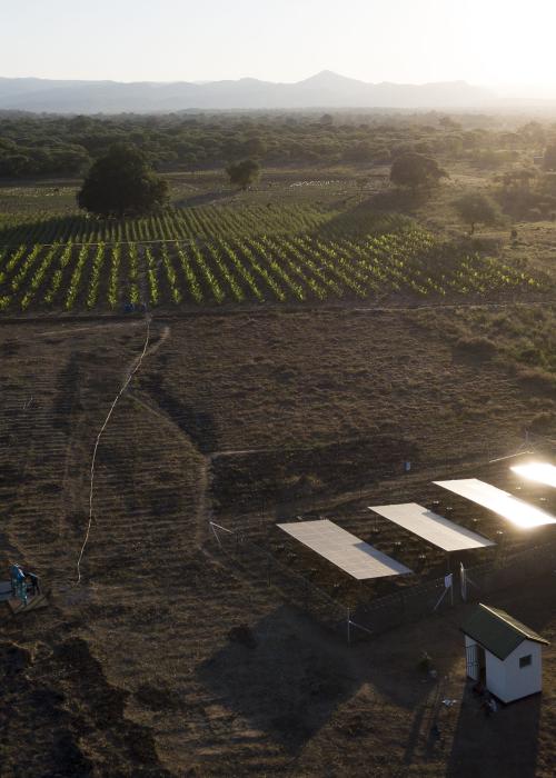 Overhead view of a small farm operation powered by a solar panel array in the bottom corner.